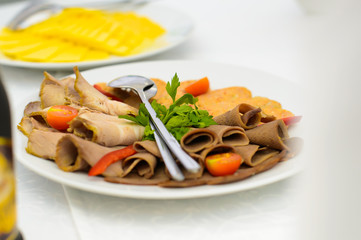A dish of sliced pork. Cold appetizer on the table. The food for the Banquet. Holiday.A plate with pieces of meat. Serving. The table decorations, the Restaurant dish. New year's table.