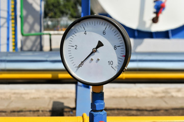 Рressure meter with yellow pipe in natural gas treatment plant in bright sunny summer day