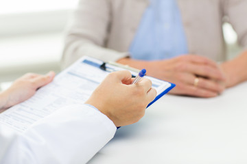 close up of senior woman and doctor with clipboard