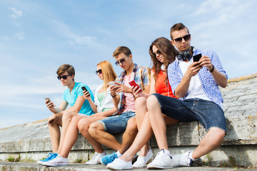 group of friends with smartphone outdoors