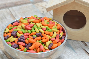 bird food in bowl and little wood house