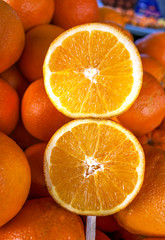 Closeup of sliced oranges on stick in market
