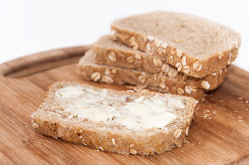 Fototapeta na wymiar Brown bread with seeds coated with butter