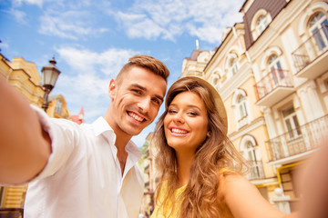 Fototapeta na wymiar couple making selfie photo on a background of the city