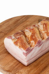 A piece of smoked bacon on wooden board