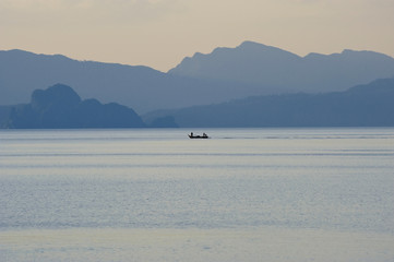 Naklejka premium Small boat on the sea during sunset..
