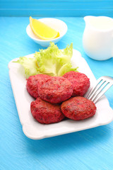cutlets of meat and beetroot on a white plate