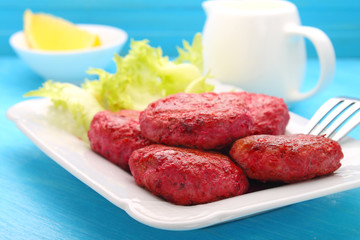 cutlets of meat and beetroot on a white plate
