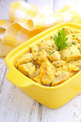 chicken curry in a yellow bowl on white background
