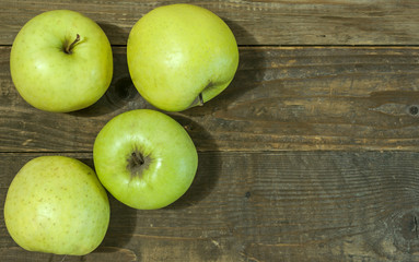 Green apples on wooden background