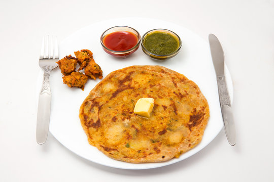 aalloo parantha and pakode an ideal indian breakfast served with tomato sauce or ketchup and green chutney