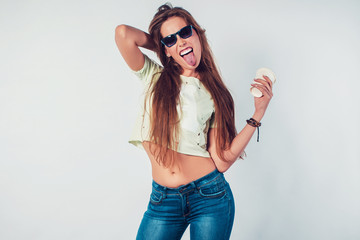 Young hipster woman showing tongue with sunglasses and takeway