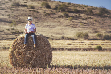 niño leyendo un libro en el campo