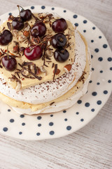 Pavlova cake with fresh cherry on the ceramic plate vertical