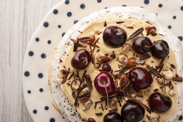 Pavlova cake with fresh cherry and chocolate chips in the ceramic plate top view