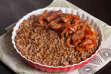 Buckwheat with meat and vegetables on wooden table