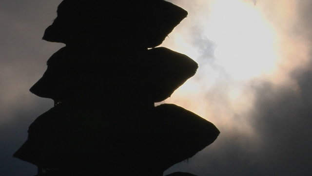 Part of a Balinese temple stands in silhouette.