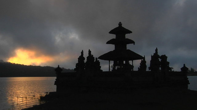 A Balinese temple overlooks reflections in a lake.