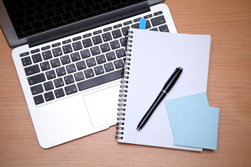 Office table with laptop, notepad and coffee cup. View from above with copy space