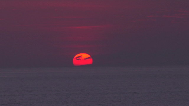 The sun hangs low in the purple sky.