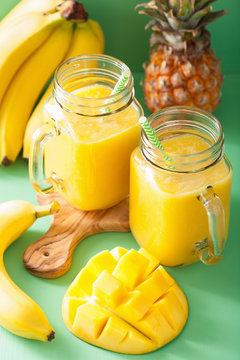 healthy mango pineapple smoothie in mason jars