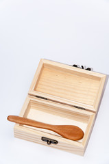 Retro wooden box with a wooden spoon over white surface