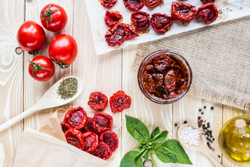dried tomatoes in an envelope of kraft paper on a wooden table covering of sackcloth.  top view