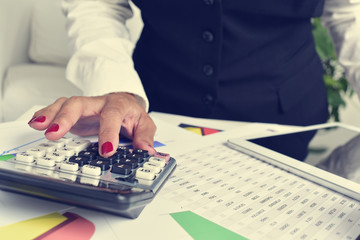businesswoman using an electronic calculator in her office