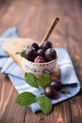Plums with napkin on wooden table