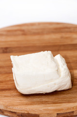 Homemade white cheese on the kitchen wooden board
