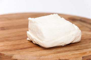Homemade white cheese on the kitchen wooden board