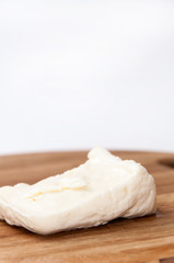 Obraz na płótnie Canvas Homemade white cheese on the kitchen wooden board