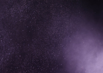 Fototapeta na wymiar purple spray water in black