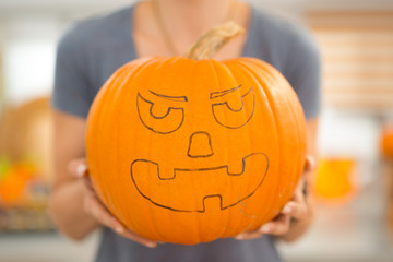 Closeup. big scary Halloween pumpkin Jack-O-Lantern in woman's h