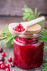 Fresh homemade cranberry sauce in a glass on dark wooden background
