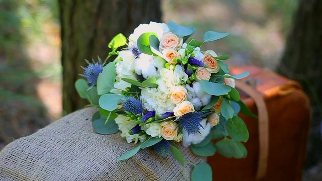 Beautiful wedding bouquet of fresh flowers and cotton on old vintage suitcase