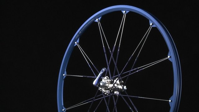 A blue bicycle rim rotates around.