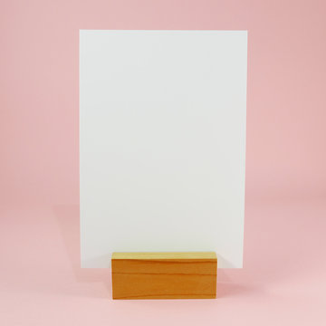 Blank menu card with wooden standing dock on pink background. (#1)