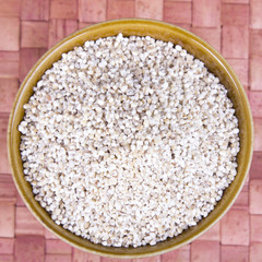 barley groats in a brown bowl 
