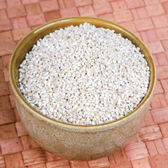 barley groats in a brown bowl 
