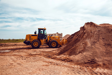 Obraz premium Excavator Loads Gravel into a Truck on a Crushed Stone Quarry