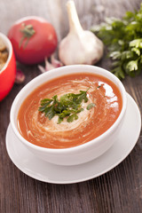 Delicious tomato soup with aromatic spices on a wooden table.