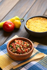 Traditional Chilean Pebre sauce made of tomato, onion, aji verde (small green hot pepper), lemon juice and coriander leaves photographed with natural light (Selective Focus, Focus in middle of pebre)