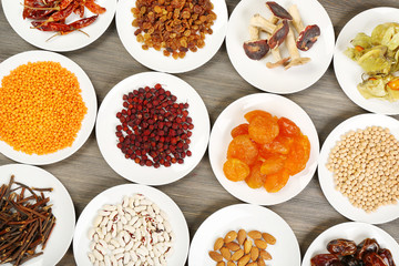 Different products on saucers on wooden table, closeup