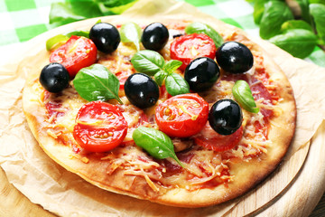 Tasty pizza with vegetables and basil on table close up