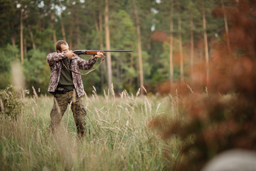 Young male hunter in camouflage clothes ready to hunt  with hunt