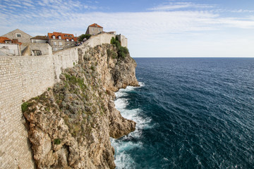 Fototapeta na wymiar Scenic view of the city walls, steep cliff and ocean in Dubrovnik, Croatia.
