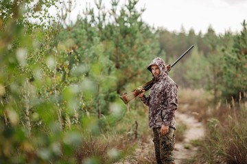 Young male hunter in camouflage clothes ready to hunt  with hunt