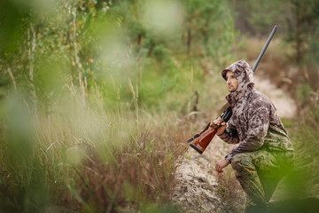 Young male hunter in camouflage clothes ready to hunt  with hunt