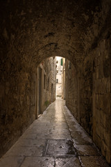 Obraz premium Narrow and empty tunnel and alley or pedestrian street at the old town in Split, Croatia.